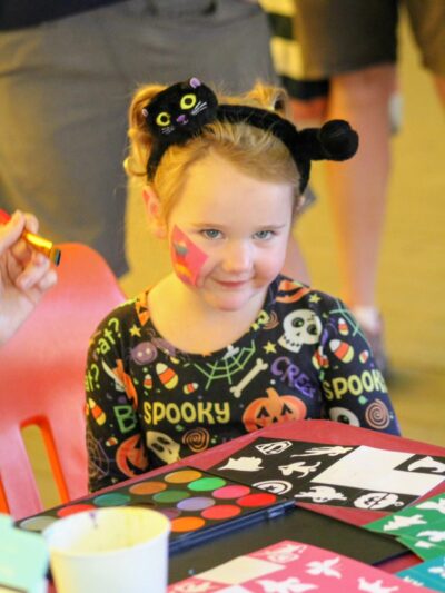 a very young girl smiling with a halloween shirt