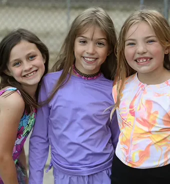 3 adolescent girls smiling for camera